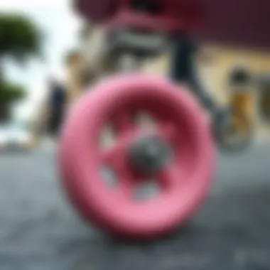 Close-up of a pink skateboard wheel against a backdrop of a city street.